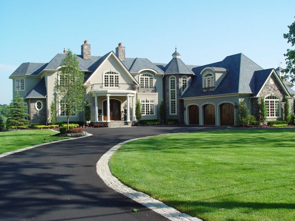 french colonial house with driveway in front of it 