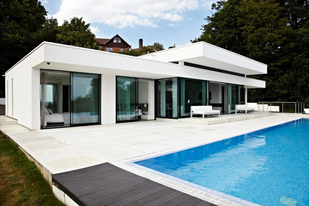 A modern house with a swimming pool in front of it
