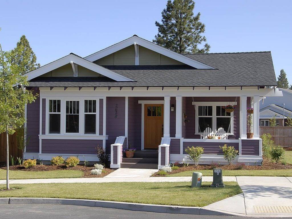A purple house with white trim and a brown door
