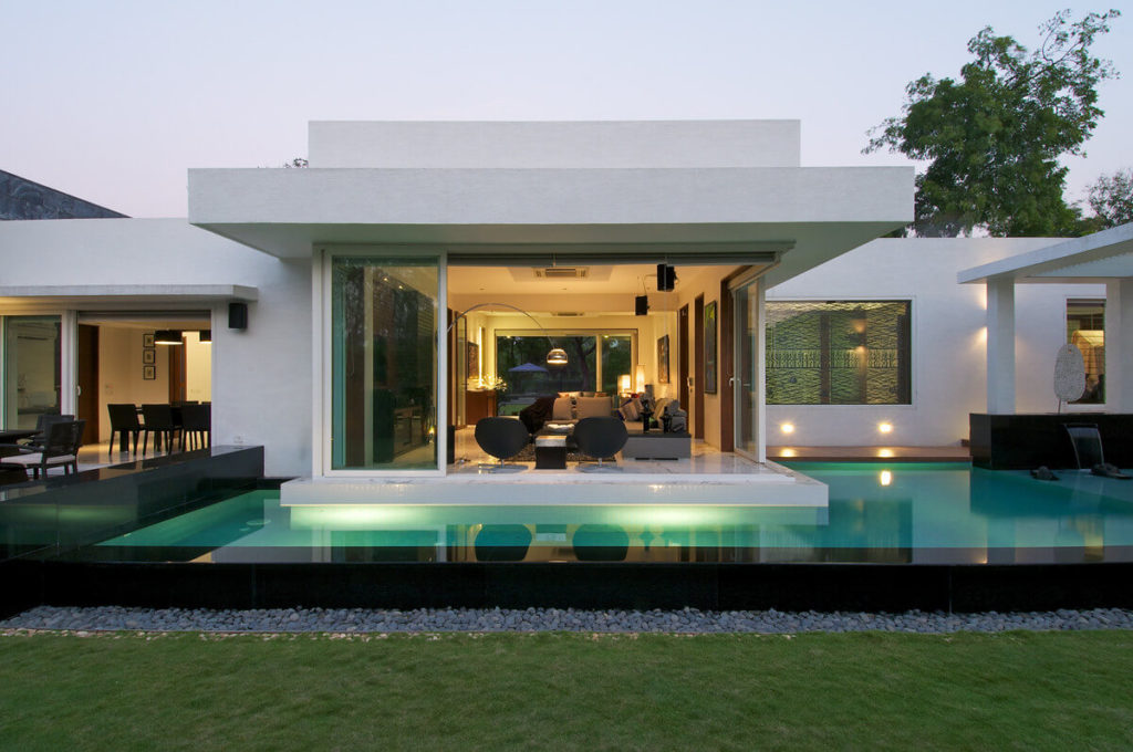 A modern house with a pool in front of it
