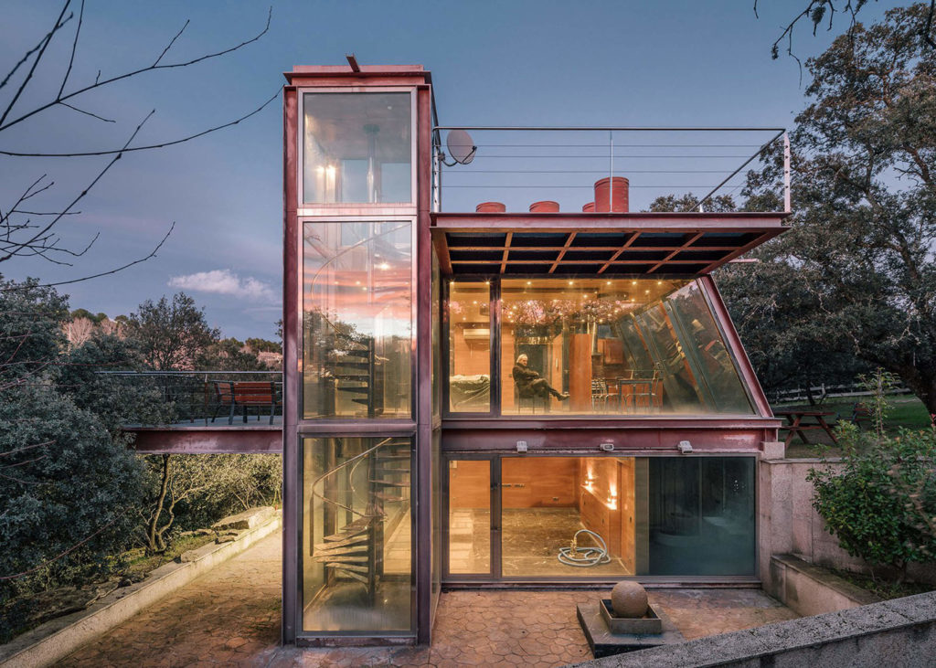 glass home with a staircase leading up to it