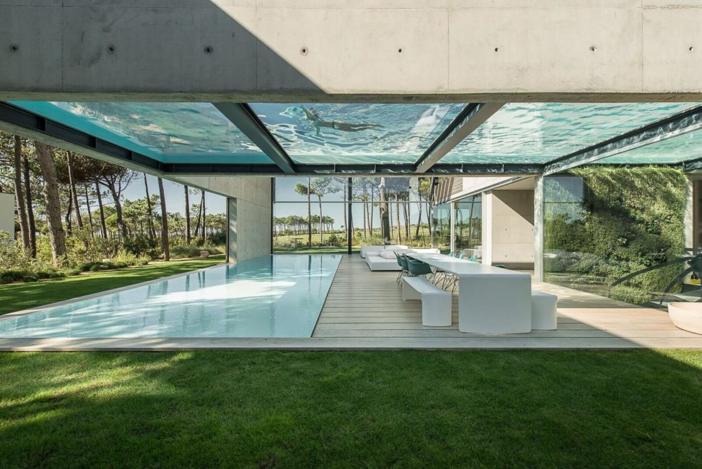 glass house architecture with a swimming pool in the middle