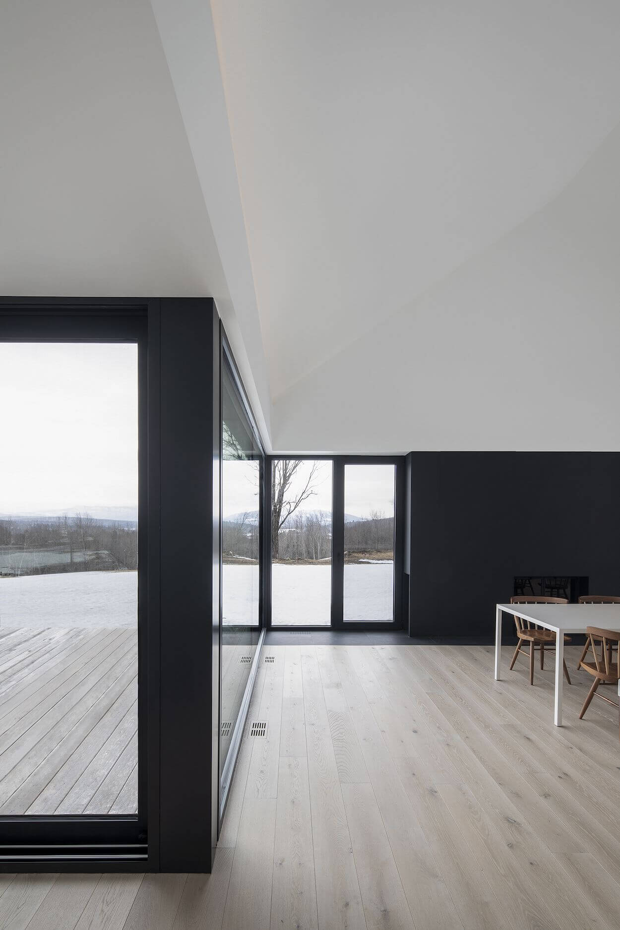 A room with a table and chairs and a sliding glass door
