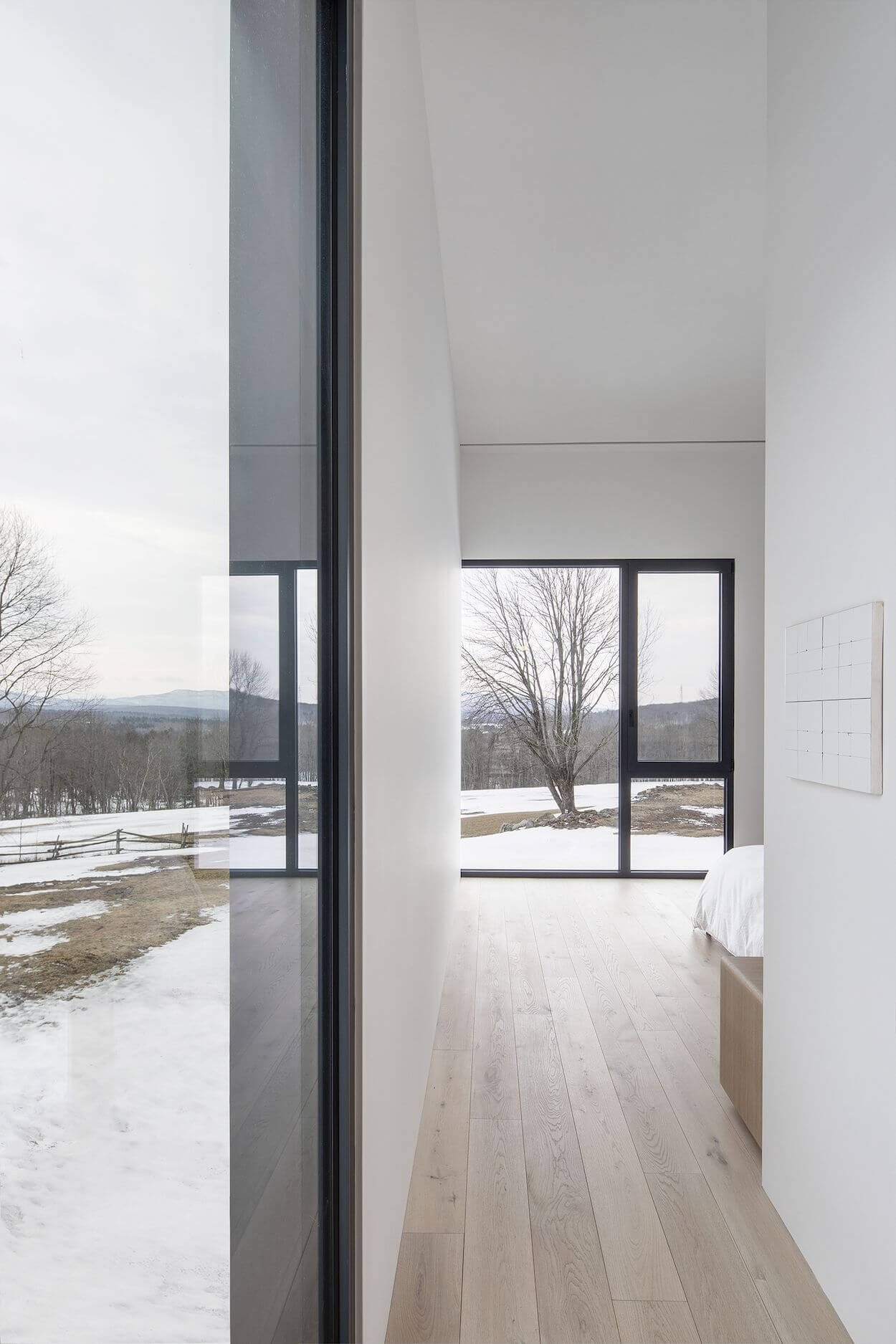 A bedroom with a wooden floor and white walls
