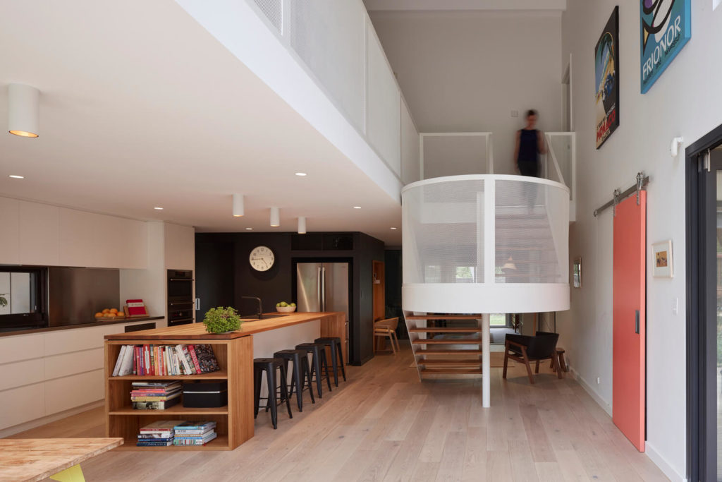 A room with a staircase and a table with chairs
