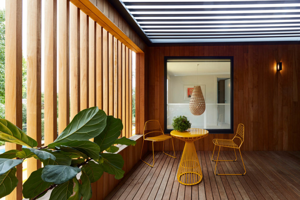 A yellow table and chairs on a wooden deck
