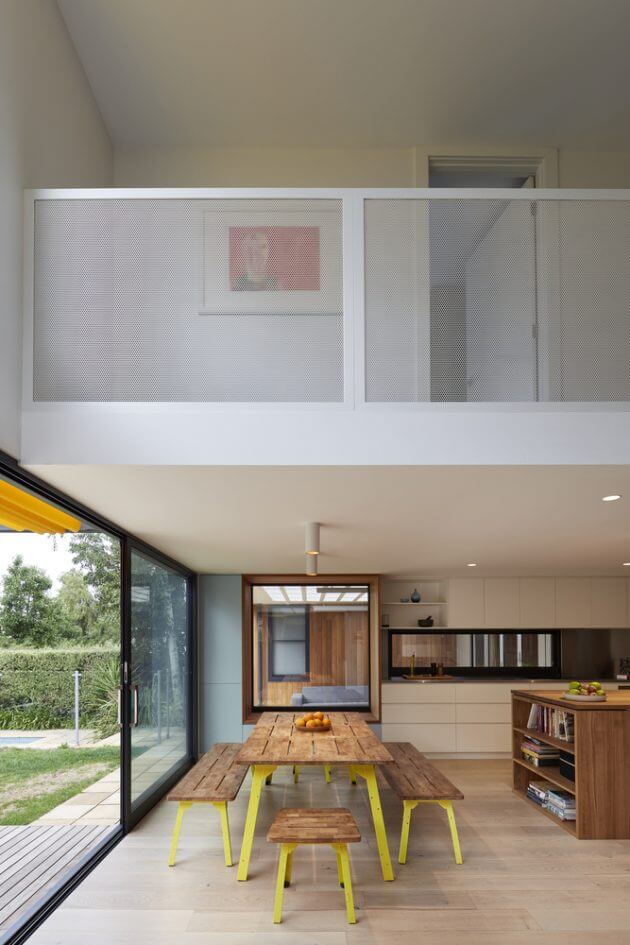 A kitchen with a wooden table and yellow benches
