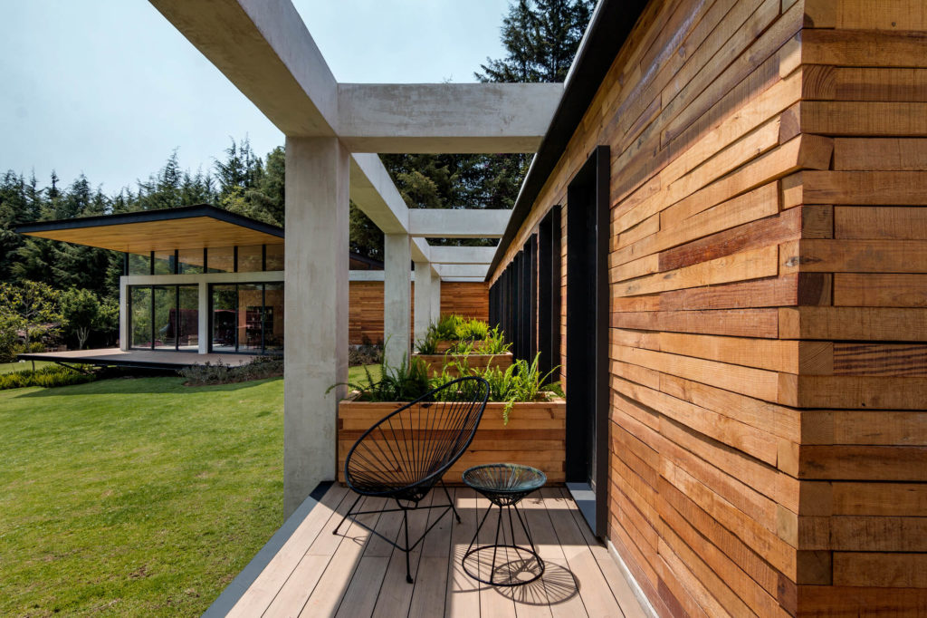 A wooden deck with a chair and potted plants
