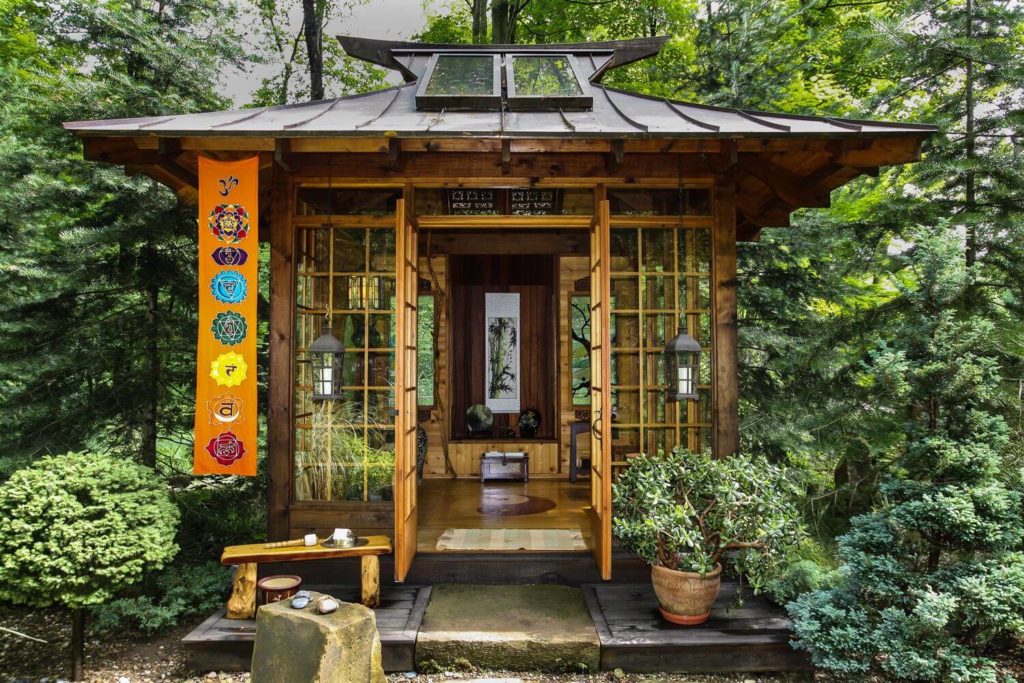 japanese tea house with a wooden roof in the middle of a forest 