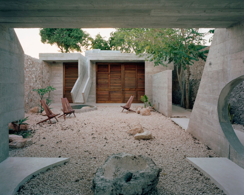 Merida House with a rock and gravel yard 