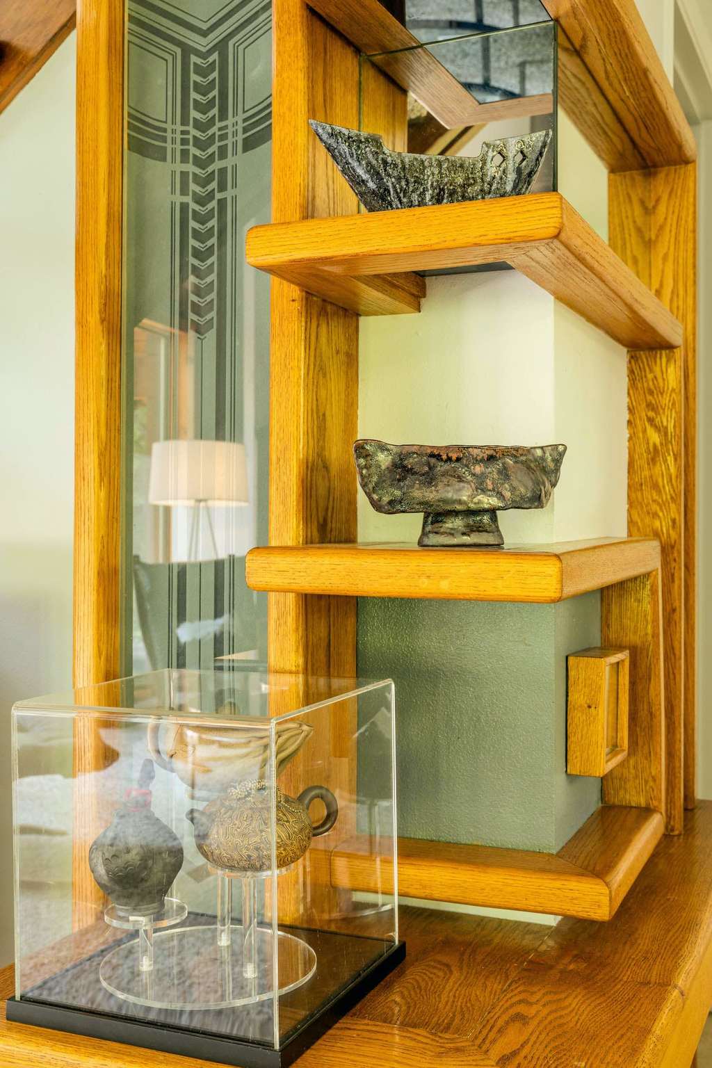 A wooden shelf with a glass case on top of it
