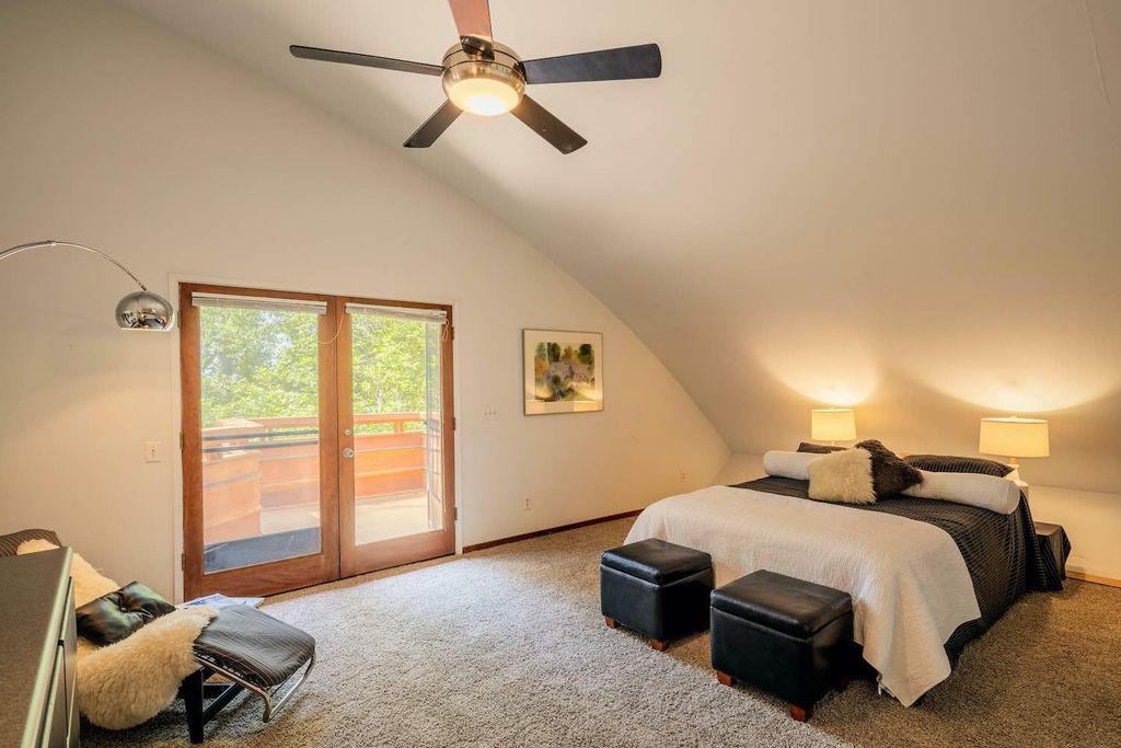The Creek House bedroom with a large bed and a ceiling fan