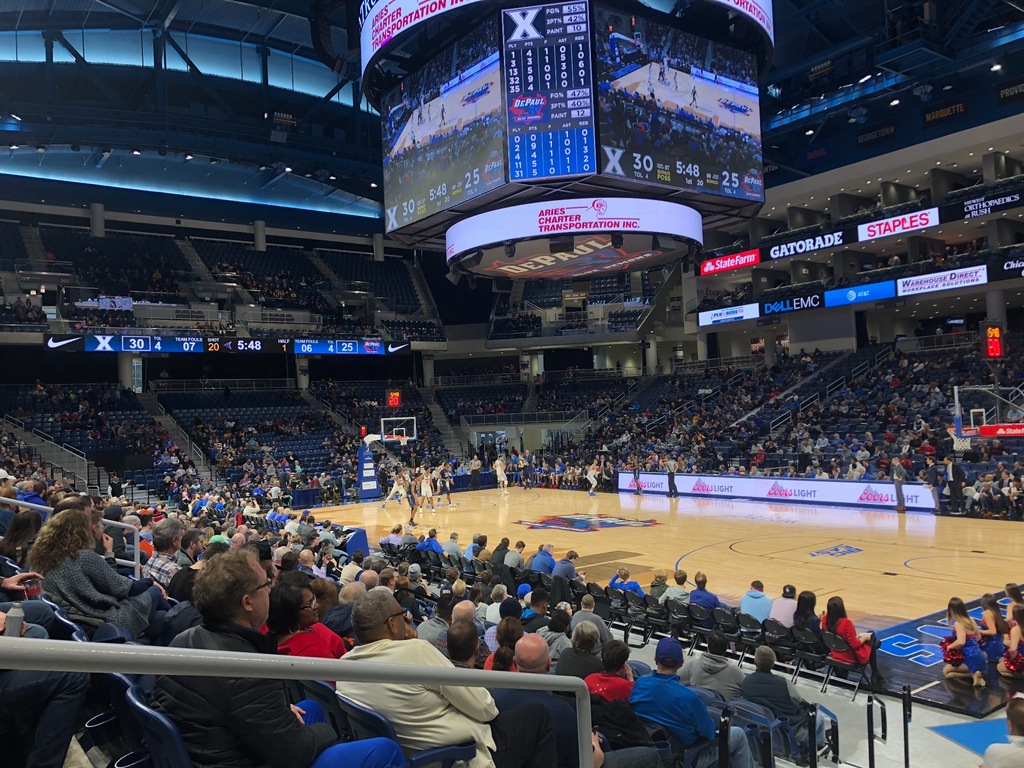 A basketball game is being played in a large arena
