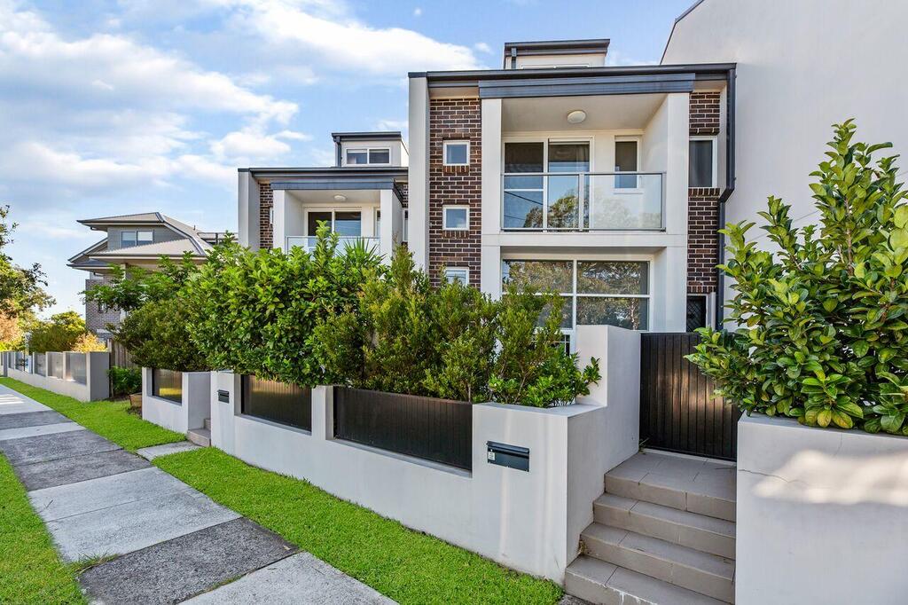 A row of houses with plants in front of them
