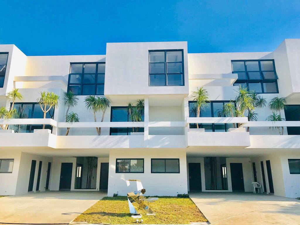 A large white modern townhouse with lots of windows
