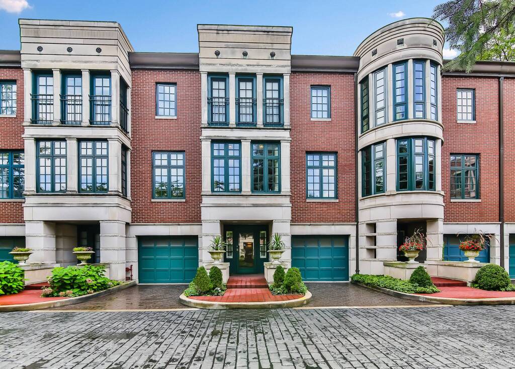 A large brick modern townhouse with lots of windows

