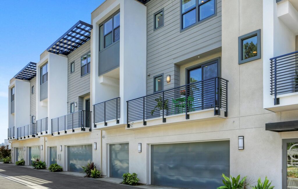 A row of apartment buildings with garages and balconies
