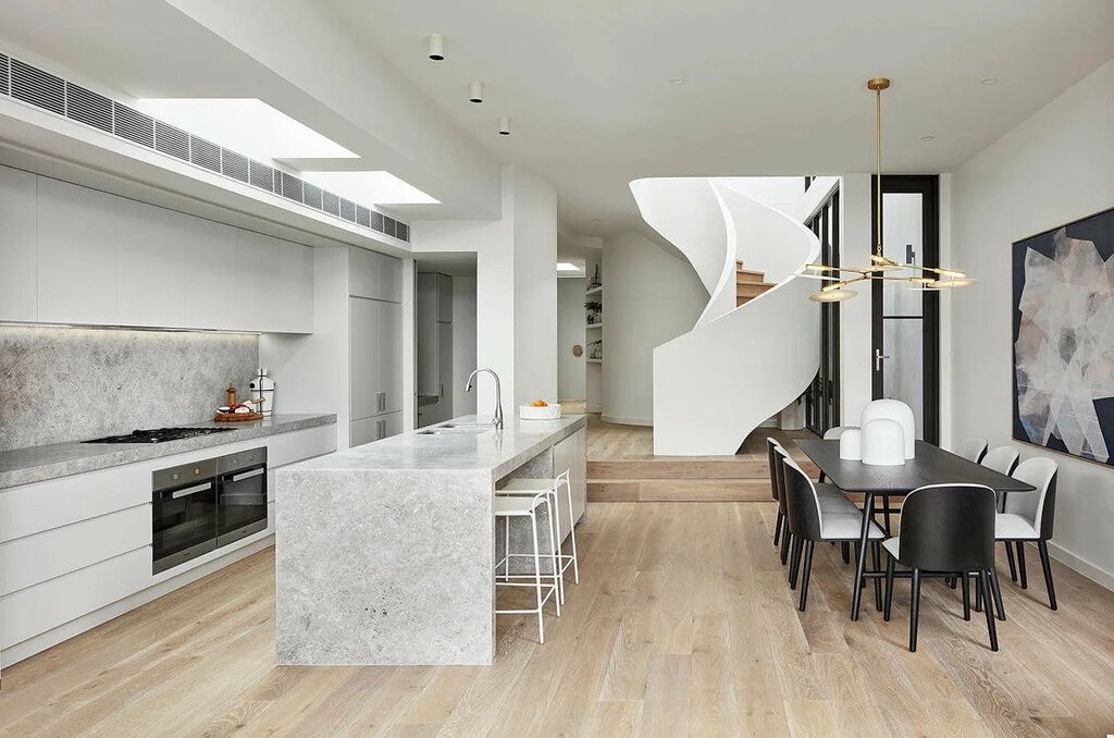 A kitchen and dining room with a spiral staircase
