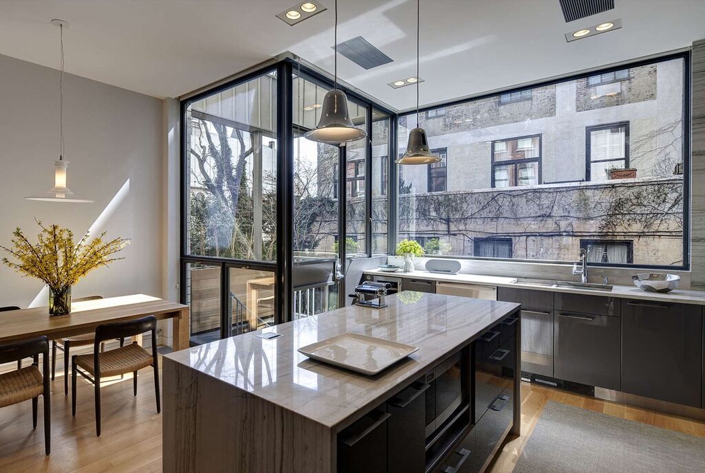 modern townhouse kitchen with a large island and a dining room table
