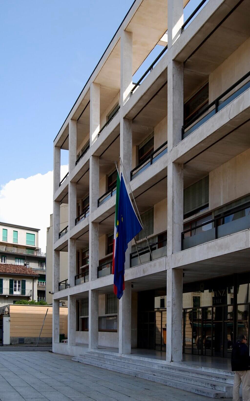 casa del fascio  with a flag on the outside of it 