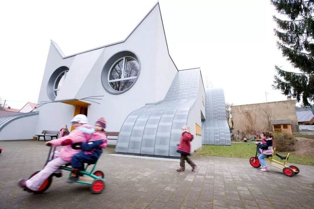 children riding bicycle in front of Kindergarten Wolfartsweier building