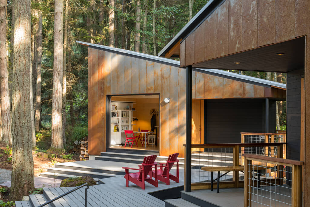 Little House Big Shed with  wooden deck with red chairs and a red table
