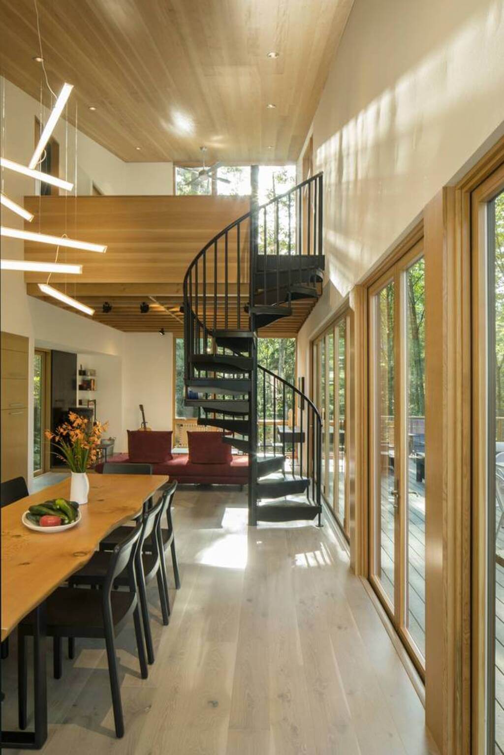 Little House Big Shed dining room with a spiral staircase leading up to a room