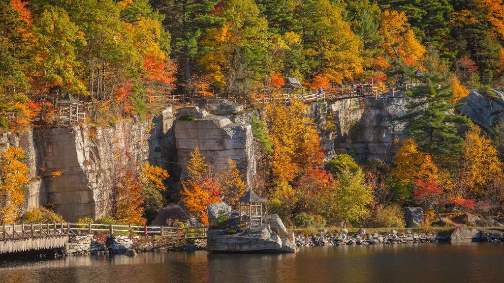 A wooden bridge over a body of water surrounded by trees
