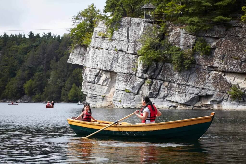 A couple of people in a small boat on a lake
