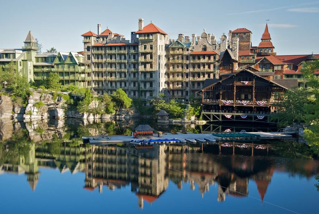 A lake surrounded by tall buildings next to a forest
