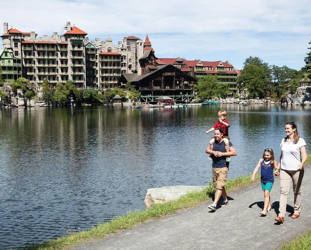 A group of people walking along a path near a body of water
