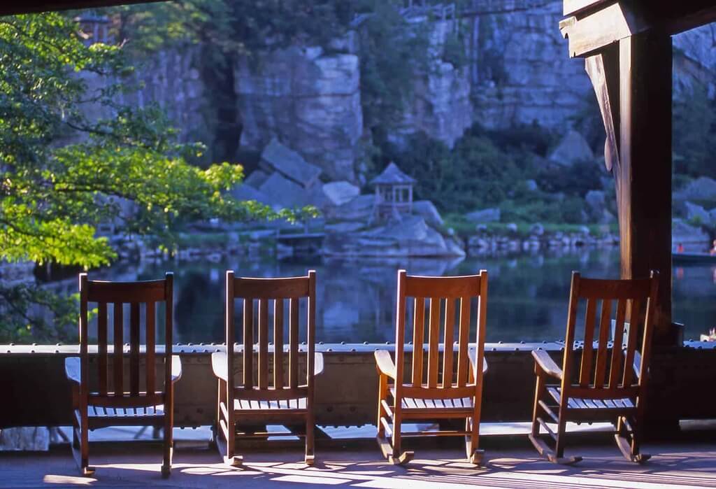 Three wooden chairs sitting next to each other on a patio
