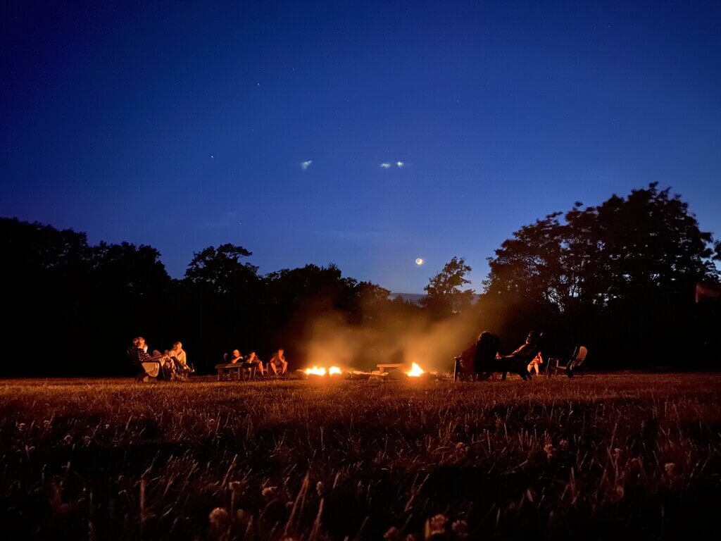A group of people sitting around a campfire
