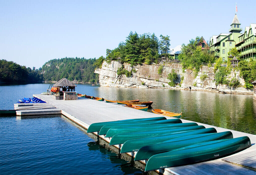 A row of canoes on a dock next to a water
