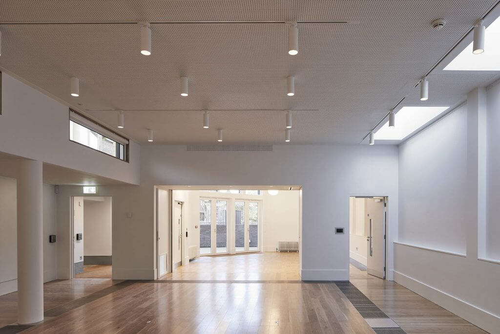 A large empty room with wooden floors and white walls
