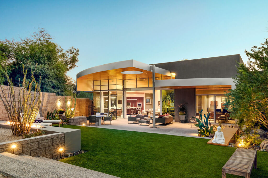 A modern home with a large lawn and patio
