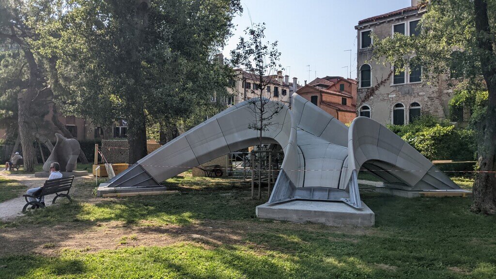 A man sitting on a park bench next to a 
Striatus Bridge