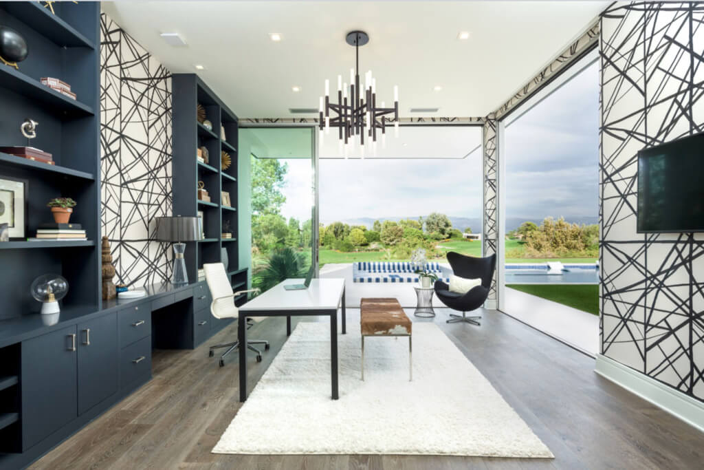 Office with a large book shelf and a tv
