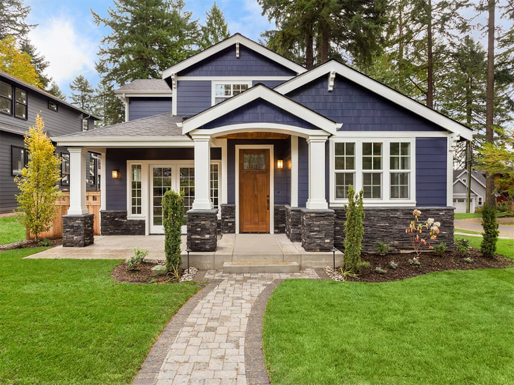 A blue house with a brick walkway leading to it
