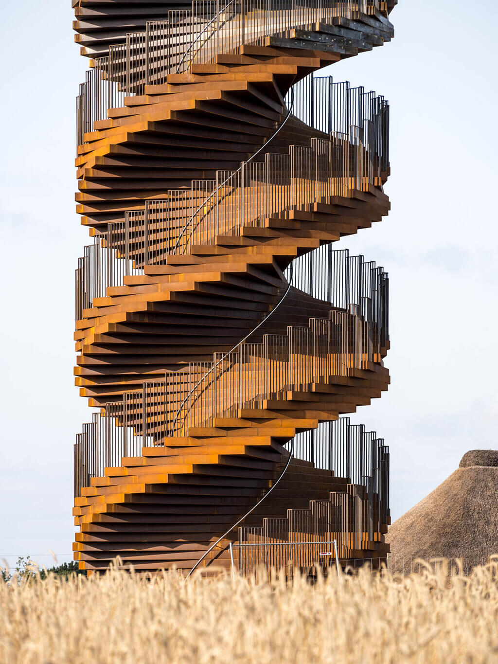 A tall building with a spiral staircase in front of it
