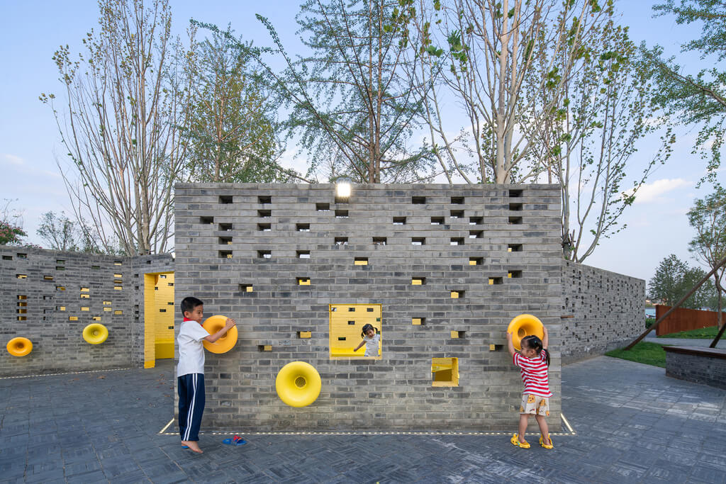 A boy and a little girl are playing with a wall
