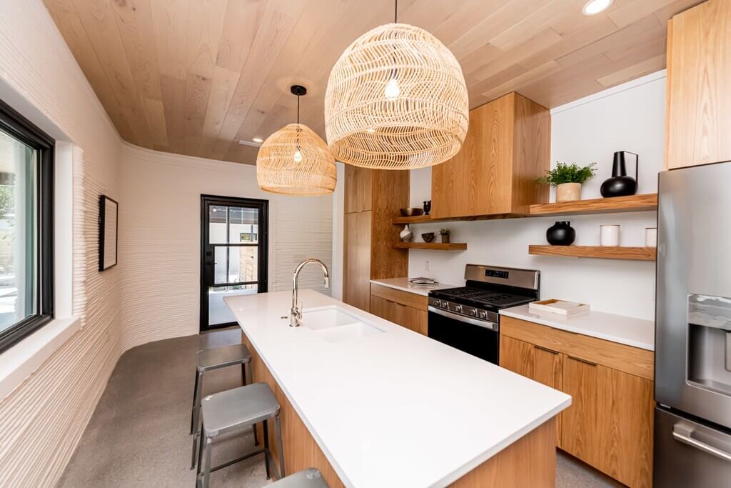 A kitchen with a sink, stove and refrigerator
