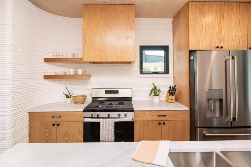 A kitchen with a stove, refrigerator, and sink
