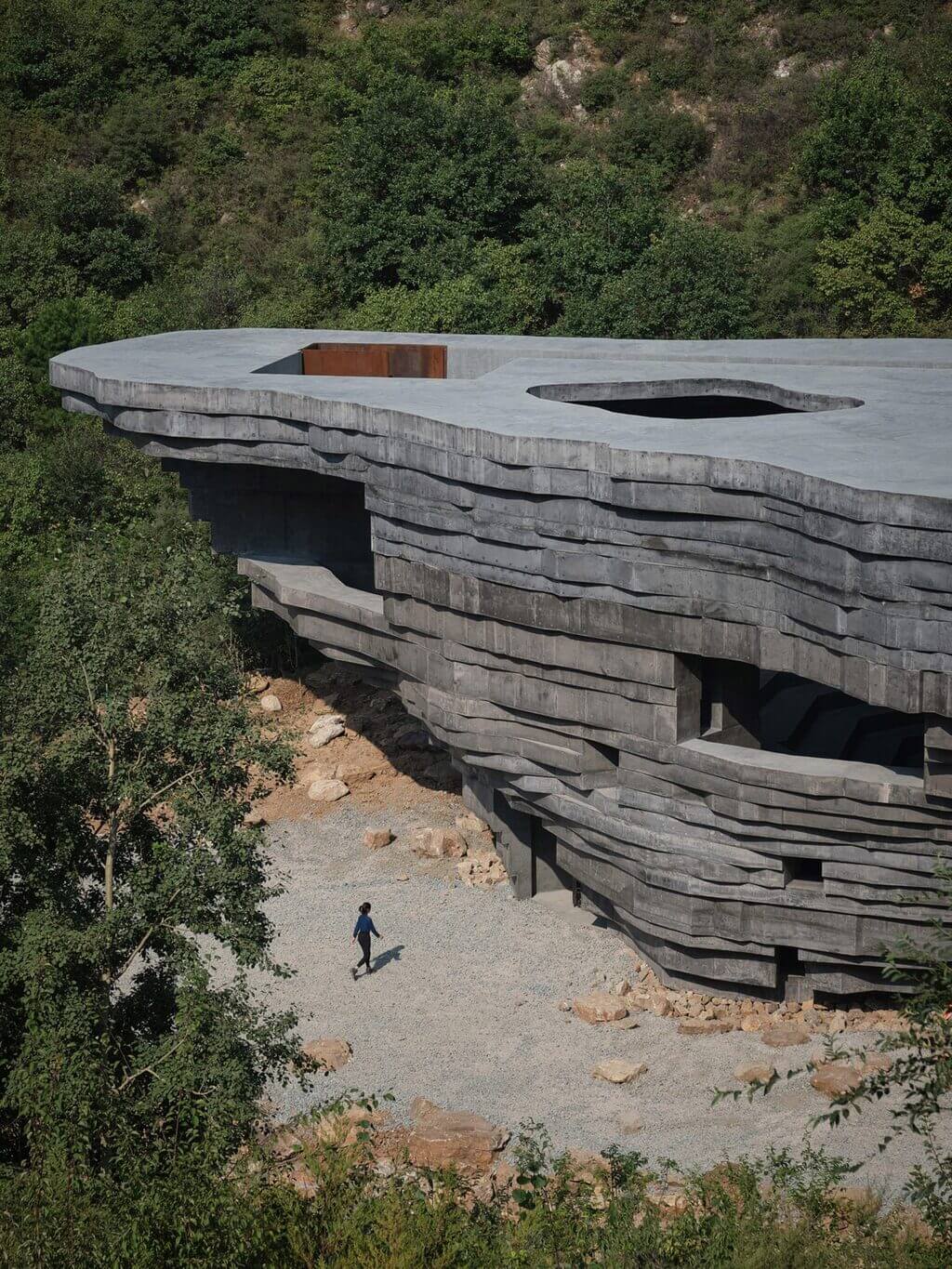 A person walking on a path next to Chapel of Sound by OPEN Architecture