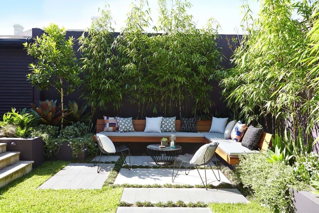 A garden with a couch, table and plants
