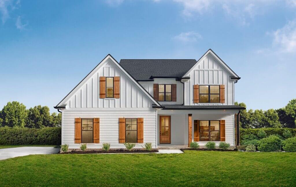 A white house with brown shutters and a black roof
