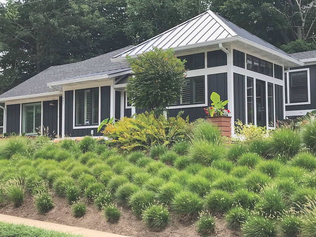 A house with a lot of plants in front of it 