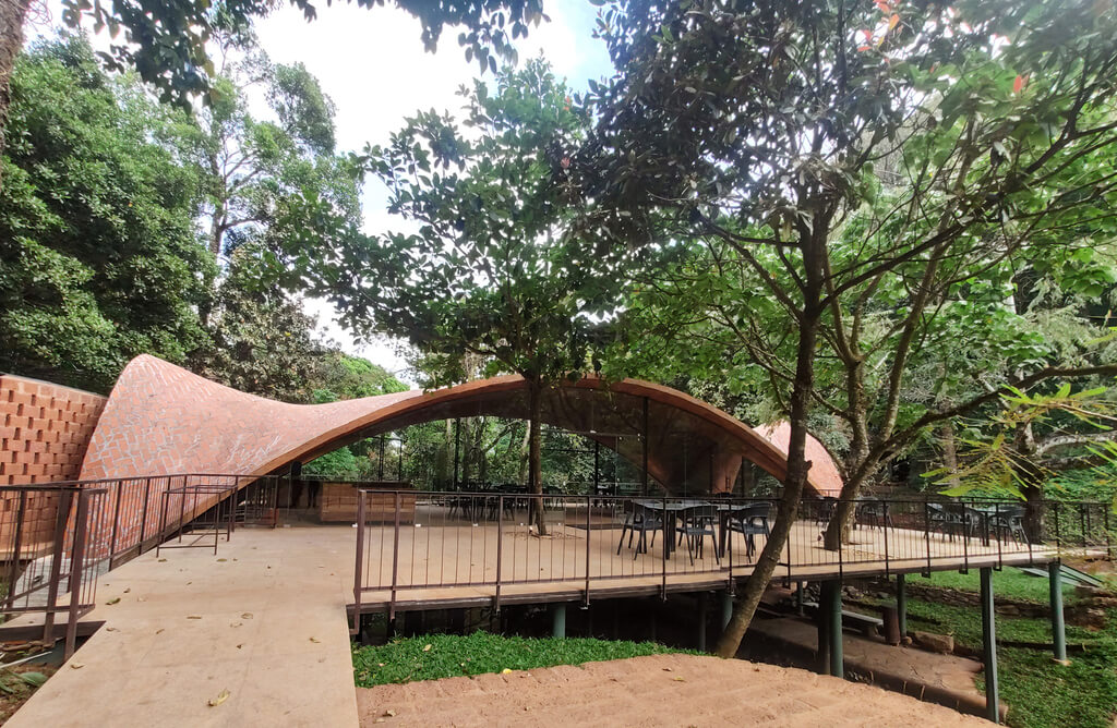 A wooden walkway leading to a pavilion surrounded by trees
