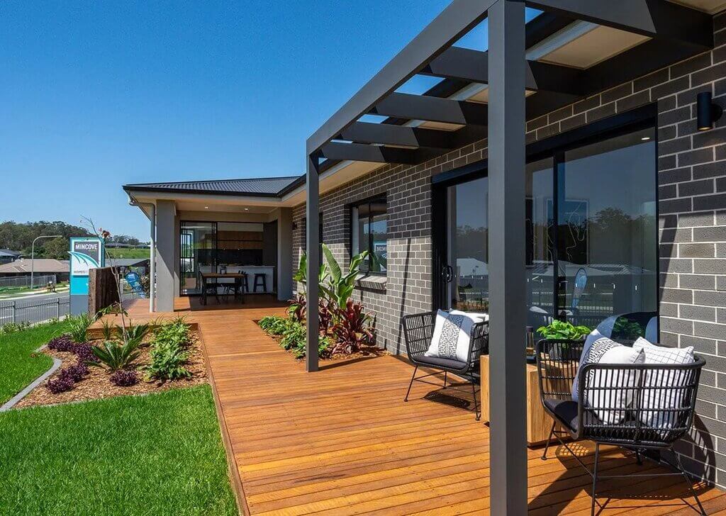 A wooden deck with chairs and plants on it
