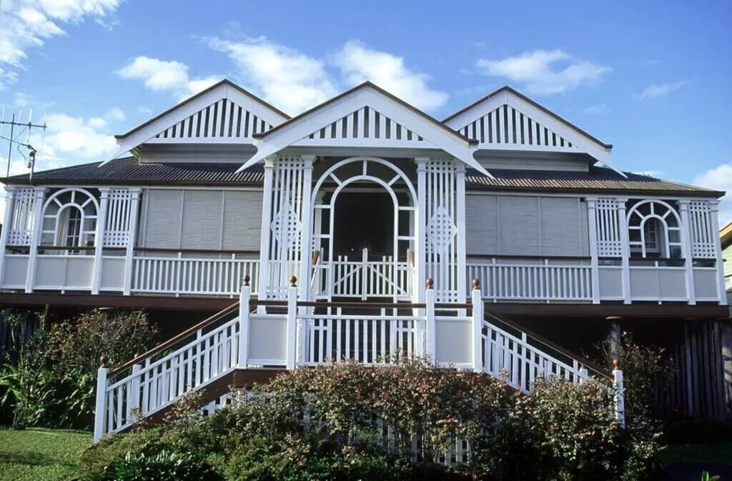A large white Queenslander homes with a balcony and balconies